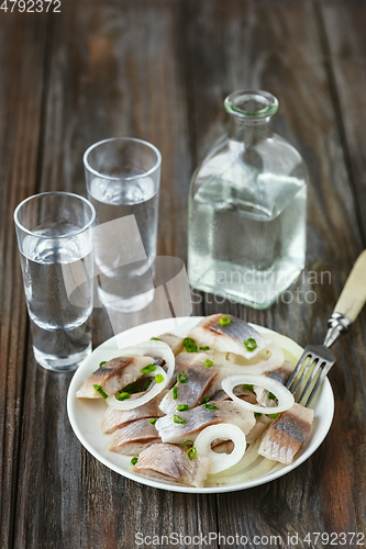 Image of Vodka and traditional snack on wooden background