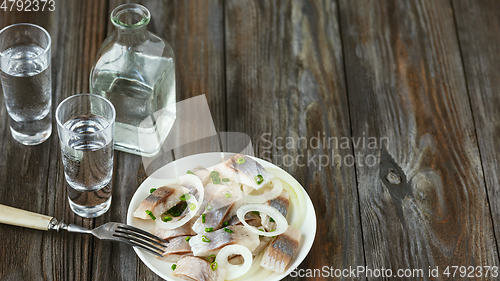 Image of Vodka and traditional snack on wooden background