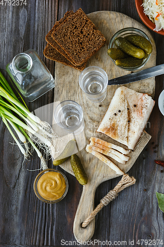 Image of Vodka and traditional snack on wooden background