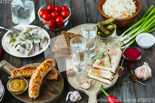 Image of Vodka and traditional snack on wooden background