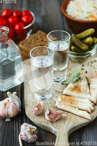 Image of Vodka and traditional snack on wooden background