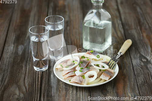 Image of Vodka and traditional snack on wooden background