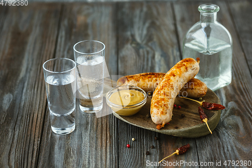 Image of Vodka and traditional snack on wooden background