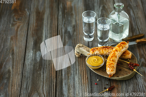 Image of Vodka and traditional snack on wooden background