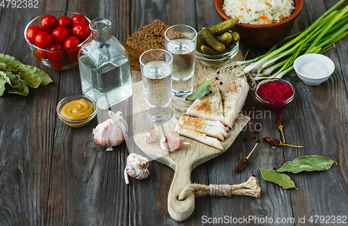 Image of Vodka and traditional snack on wooden background