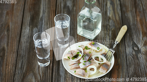 Image of Vodka and traditional snack on wooden background