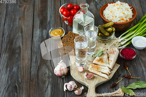 Image of Vodka and traditional snack on wooden background