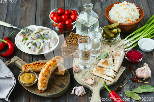 Image of Vodka and traditional snack on wooden background