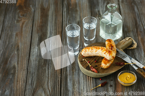 Image of Vodka and traditional snack on wooden background