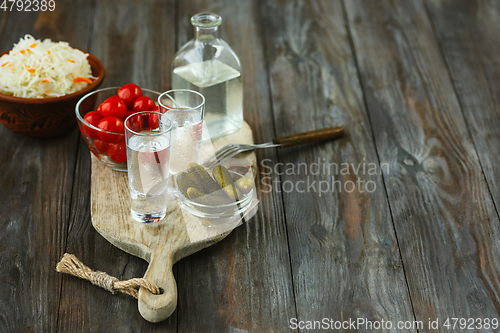 Image of Vodka and traditional snack on wooden background