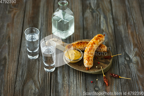 Image of Vodka and traditional snack on wooden background