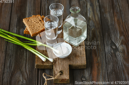 Image of Vodka and traditional snack on wooden background