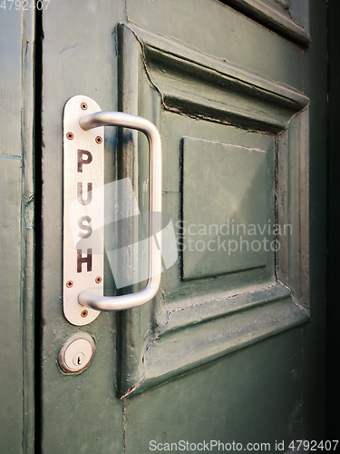 Image of Old door with door handle and the inscription push