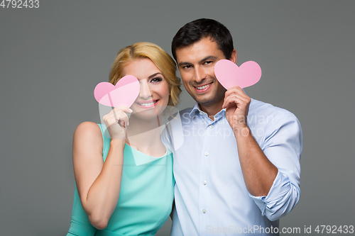 Image of Beautiful couple holding pink hearts
