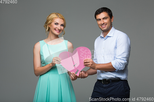 Image of Beautiful couple holding pink broken heart