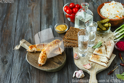 Image of Vodka and traditional snack on wooden background