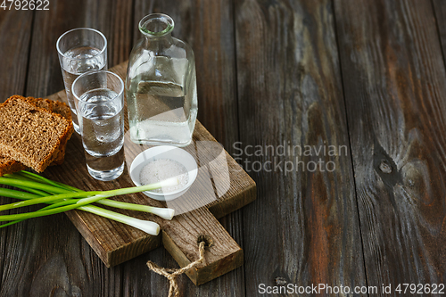 Image of Vodka and traditional snack on wooden background