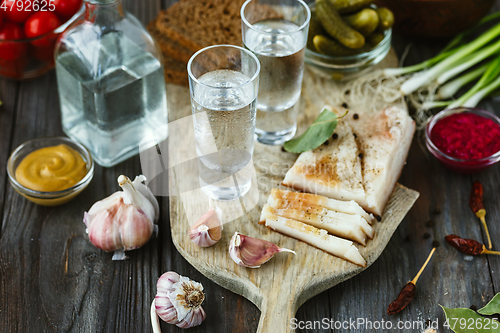 Image of Vodka and traditional snack on wooden background