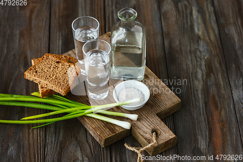 Image of Vodka and traditional snack on wooden background