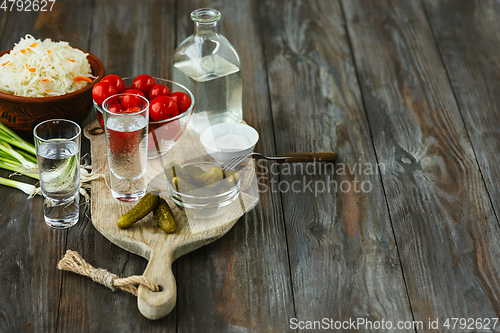 Image of Vodka and traditional snack on wooden background