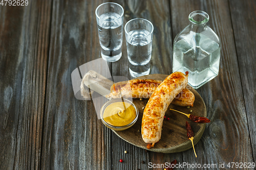 Image of Vodka and traditional snack on wooden background