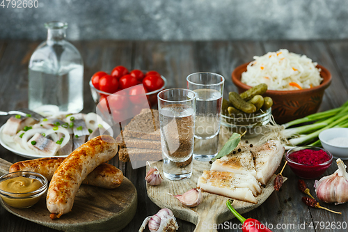 Image of Vodka and traditional snack on wooden background