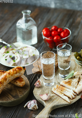 Image of Vodka and traditional snack on wooden background