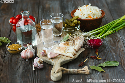 Image of Vodka and traditional snack on wooden background