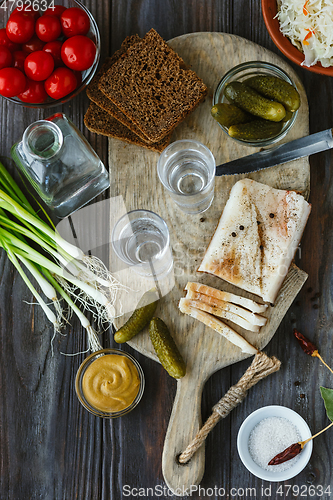 Image of Vodka and traditional snack on wooden background