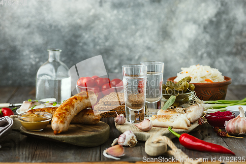 Image of Vodka and traditional snack on wooden background