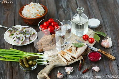 Image of Vodka and traditional snack on wooden background