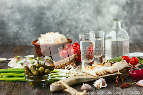 Image of Vodka and traditional snack on wooden background