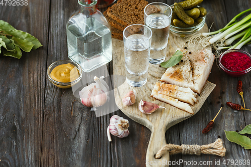 Image of Vodka and traditional snack on wooden background