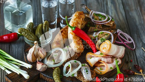 Image of Vodka and traditional snack on wooden background