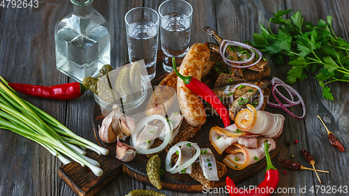 Image of Vodka and traditional snack on wooden background