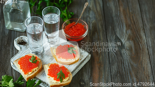 Image of Vodka and traditional snack on wooden background