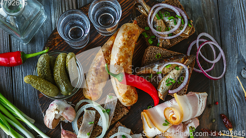 Image of Vodka and traditional snack on wooden background