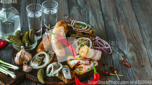 Image of Vodka and traditional snack on wooden background