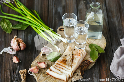 Image of Vodka and traditional snack on wooden background