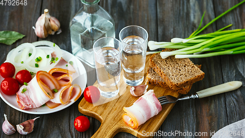 Image of Vodka and traditional snack on wooden background