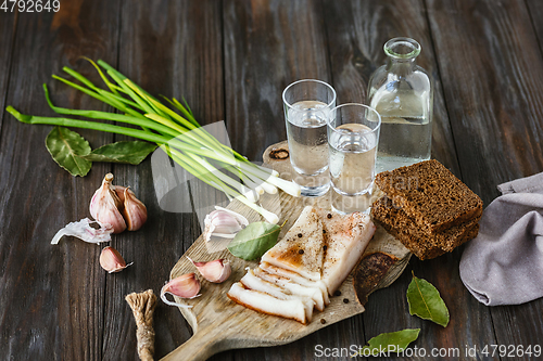 Image of Vodka and traditional snack on wooden background