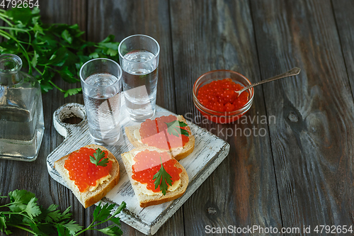 Image of Vodka and traditional snack on wooden background