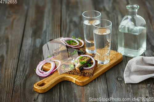 Image of Vodka and traditional snack on wooden background