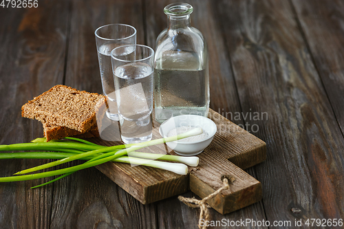 Image of Vodka and traditional snack on wooden background