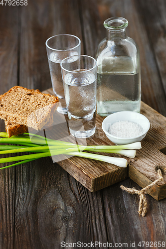 Image of Vodka and traditional snack on wooden background