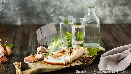 Image of Vodka and traditional snack on wooden background