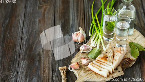 Image of Vodka and traditional snack on wooden background