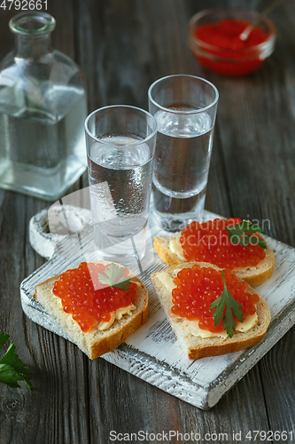 Image of Vodka and traditional snack on wooden background