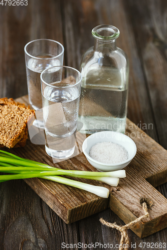 Image of Vodka and traditional snack on wooden background