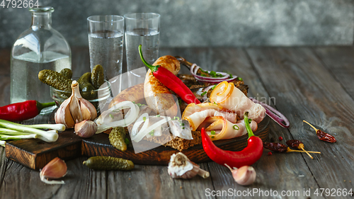 Image of Vodka and traditional snack on wooden background